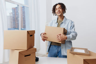 Portrait of young woman holding box