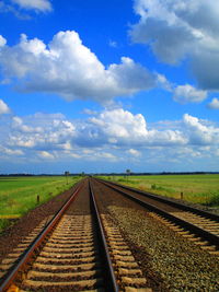 Railroad tracks on field against sky