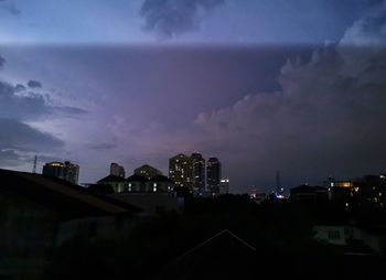 Illuminated buildings against sky at night