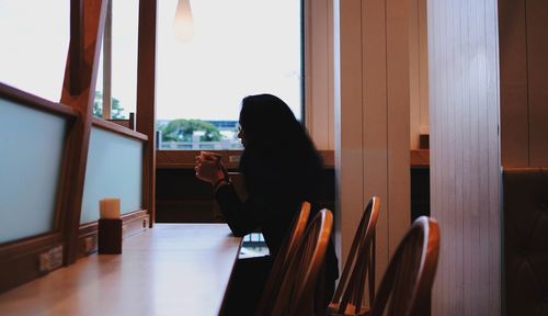 Woman sitting on table in restaurant