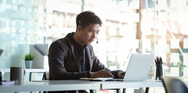 Young businessman working on laptop at office