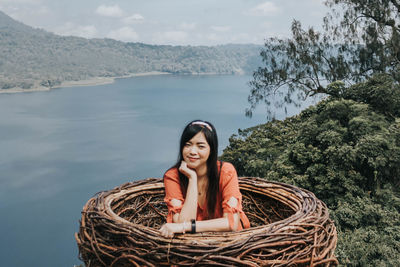 Portrait of smiling young woman against plants