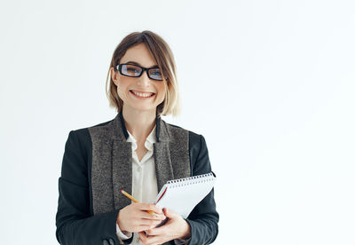 Portrait of smiling businesswoman against white background