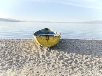 Boat moored on beach against sky