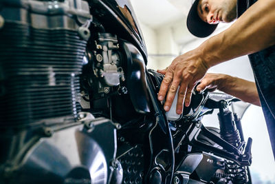 Mature mechanic repairing motorcycle in garage