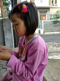 Close-up of girl looking away while sitting outdoors