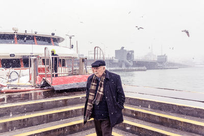 Full length of man standing in city during winter