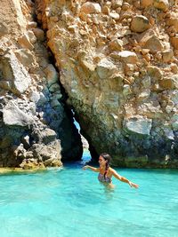 Full length of woman on rock by swimming pool