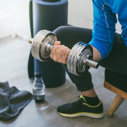 Determined sporty man working out and trains at home fit male doing exercise with weights for biceps