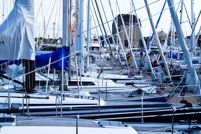 Boats moored at harbor against sky