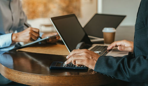 Midsection of man using laptop at office