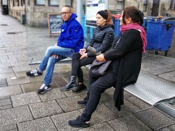 Full length of a young woman sitting in city