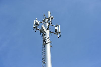 Low angle view of communications tower against clear blue sky