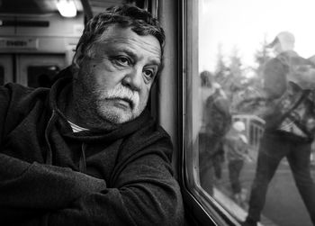 Senior man looking through train window