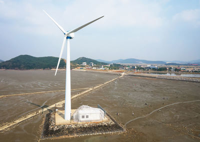 A white windmill against the sky, a renewable energy concert.