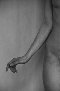 Midsection of shirtless woman over white background
