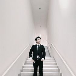 Portrait of a young man standing on steps