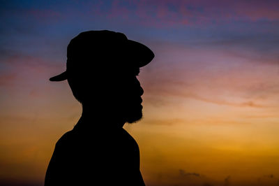 Silhouette man standing against sky during sunset