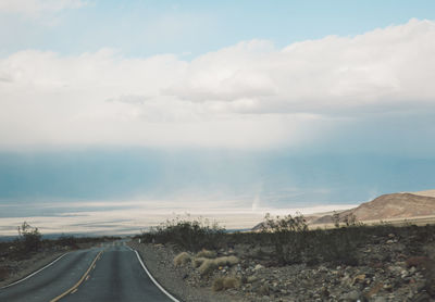 Road passing through landscape against sky