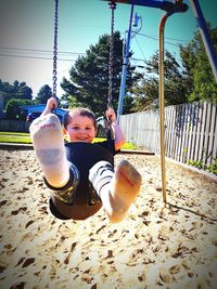 Children playing on swing at playground