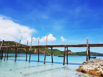 Bridge over sea against cloudy sky