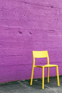 High angle view of empty chair against wall