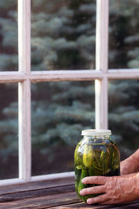 Close-up of hand holding glass window