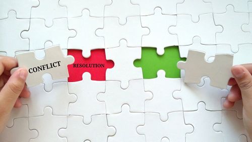 Cropped hands holding jigsaw pieces with text