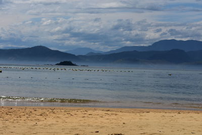 Scenic view of sea and mountains against sky