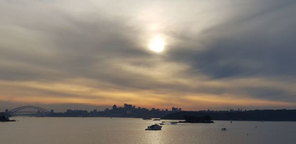 Scenic view of sea against cloudy sky during sunset