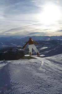 Man on snowcapped mountain against sky during winter