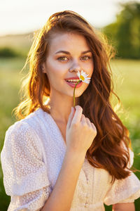 Portrait of smiling young woman blowing bubbles