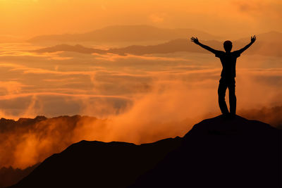 Silhouette man standing against sky during sunset