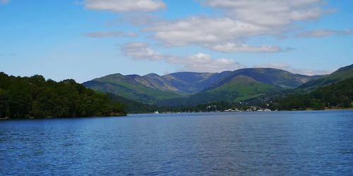 Scenic view of lake by mountains against sky