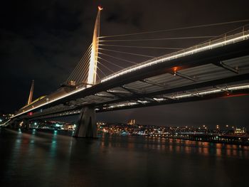 Illuminated bridge over river at night