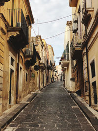 Empty alley amidst buildings in city