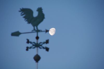 Low angle view of moon against blue sky