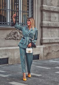 Full length of woman standing against building