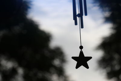 Low angle view of silhouette cross against sky