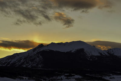 Scenic view of snowcapped mountains against sky during sunset