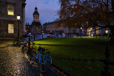 Bicycle by building in city at night