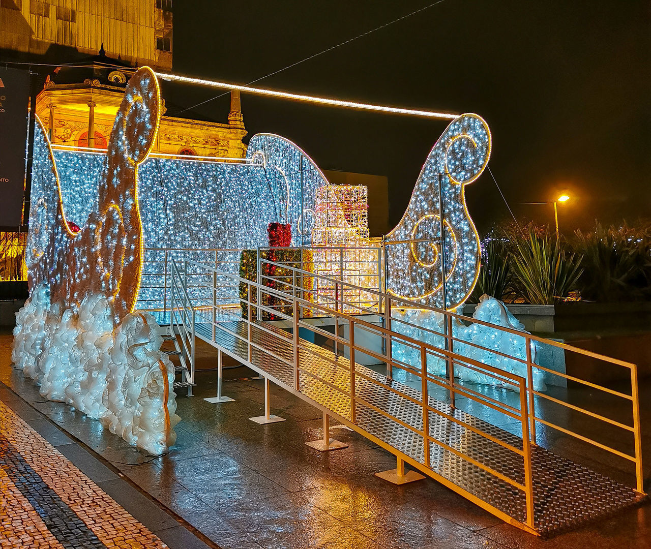 ILLUMINATED FERRIS WHEEL AGAINST RAILING AT NIGHT