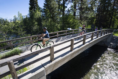 People riding bicycle on footbridge