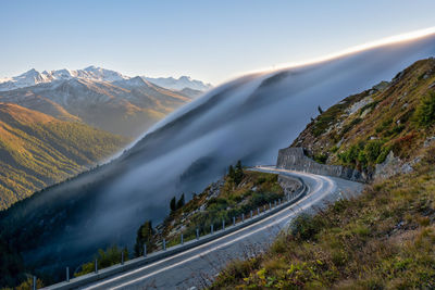 Road by mountains against sky