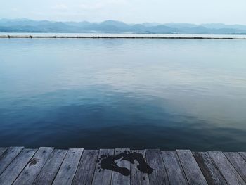 Pier on lake against sky