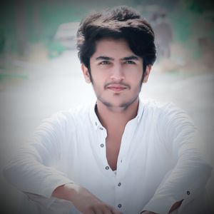 Handsome young man looking away while sitting outdoors