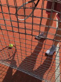 Low section of player standing by net in tennis court