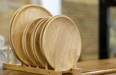 Close-up of wooden plate on the shelf