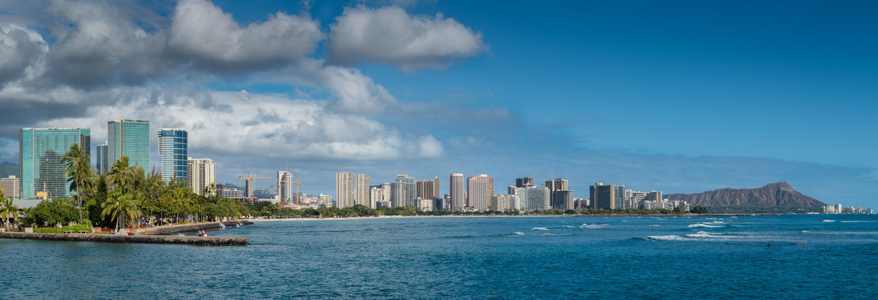 building exterior, architecture, built structure, water, city, sea, waterfront, sky, blue, skyscraper, cityscape, urban skyline, office building, modern, tall - high, tower, cloud - sky, cloud, financial district, residential building