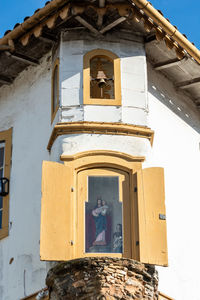 Low angle view of cross by building